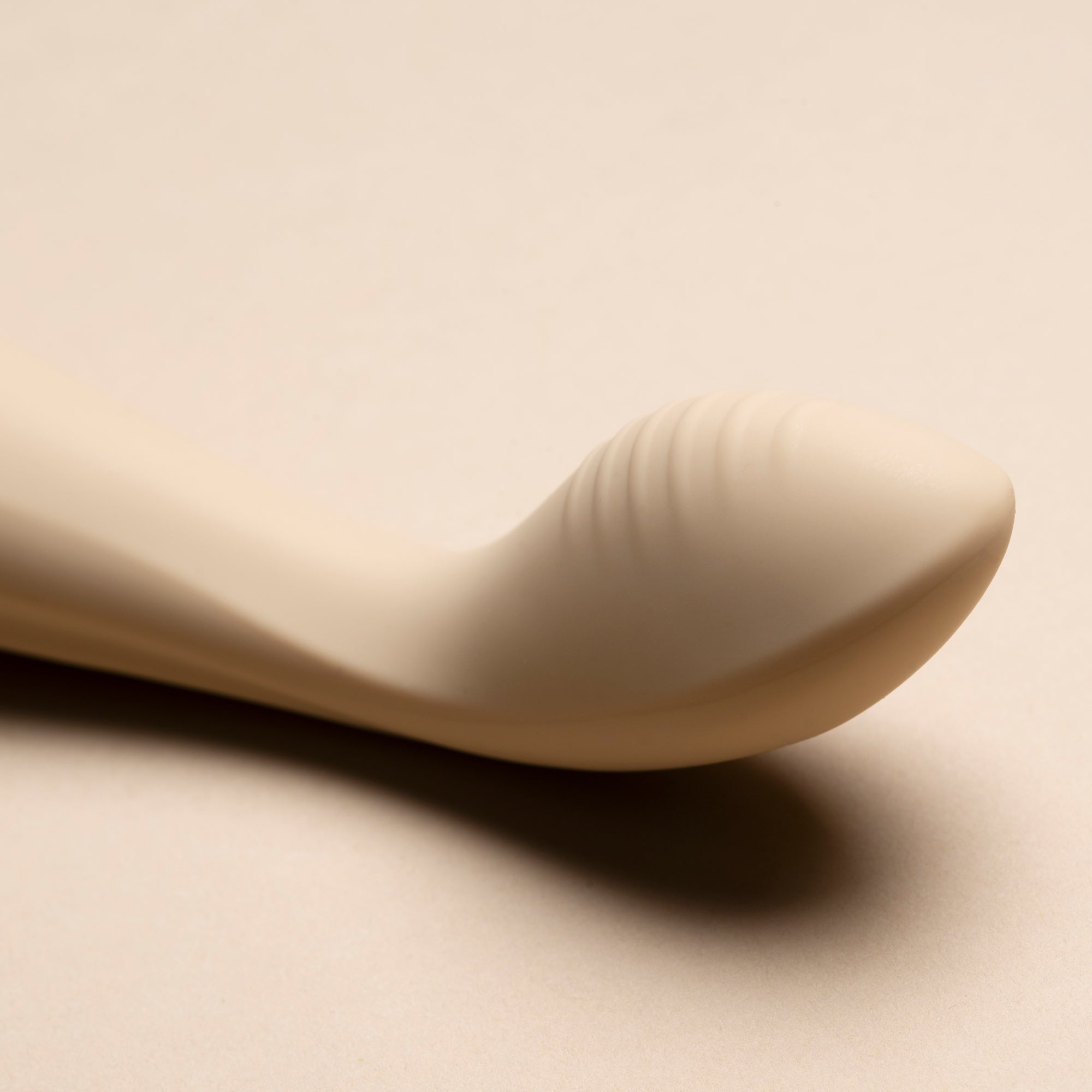 Image banner close-up of the head of a vanilla G-spot vibrator on cream background