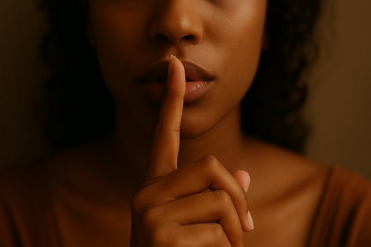 Close-up of a woman holding a finger to her lips in a quiet gesture, symbolizing privacy and discretion