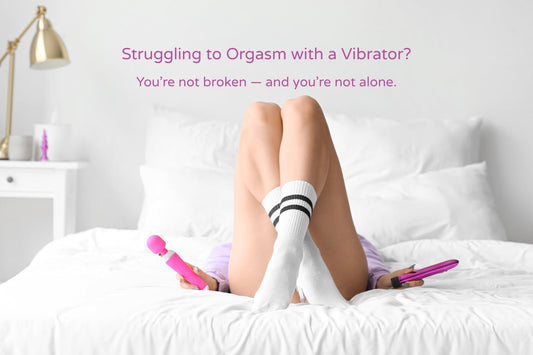 Woman lying on white bed holding two vibrators, legs up and crossed, with a neutral expression — representing indecision or frustration about finding the right vibrator.