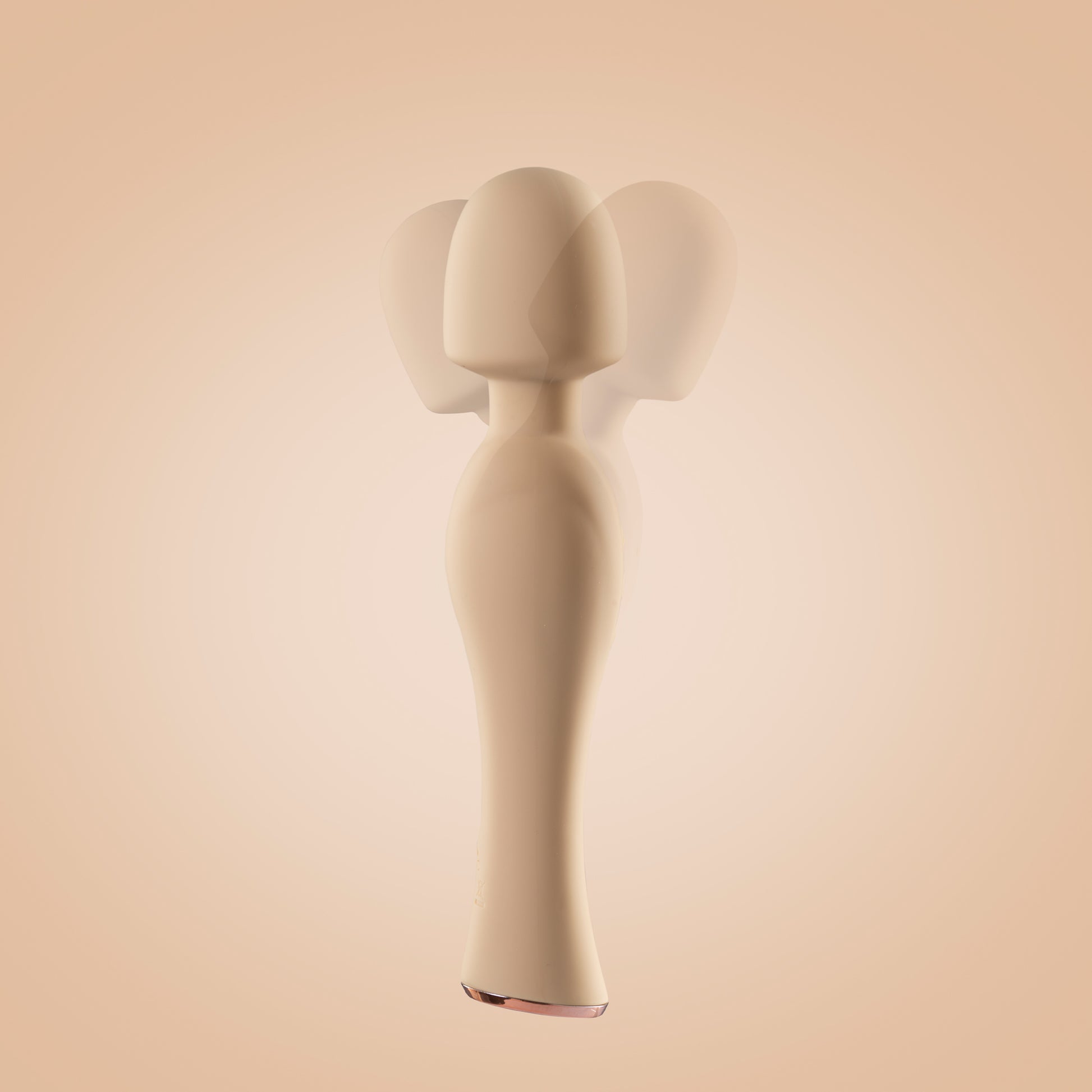 Yellow wand vibrator standing upright with motion in head, off-white background